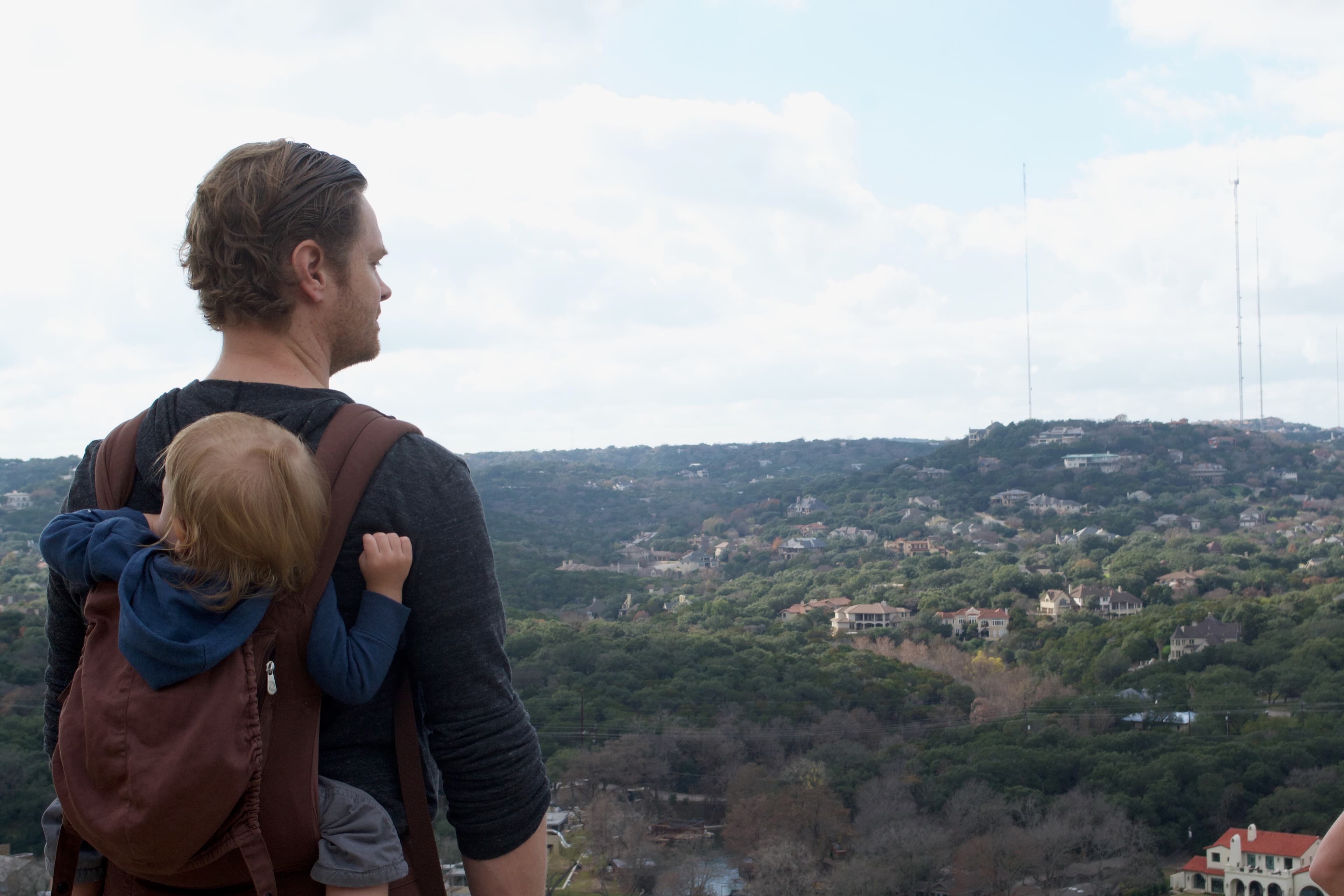 Hill Country Reverie - A father carries his child, gazing at a sprawling ...
