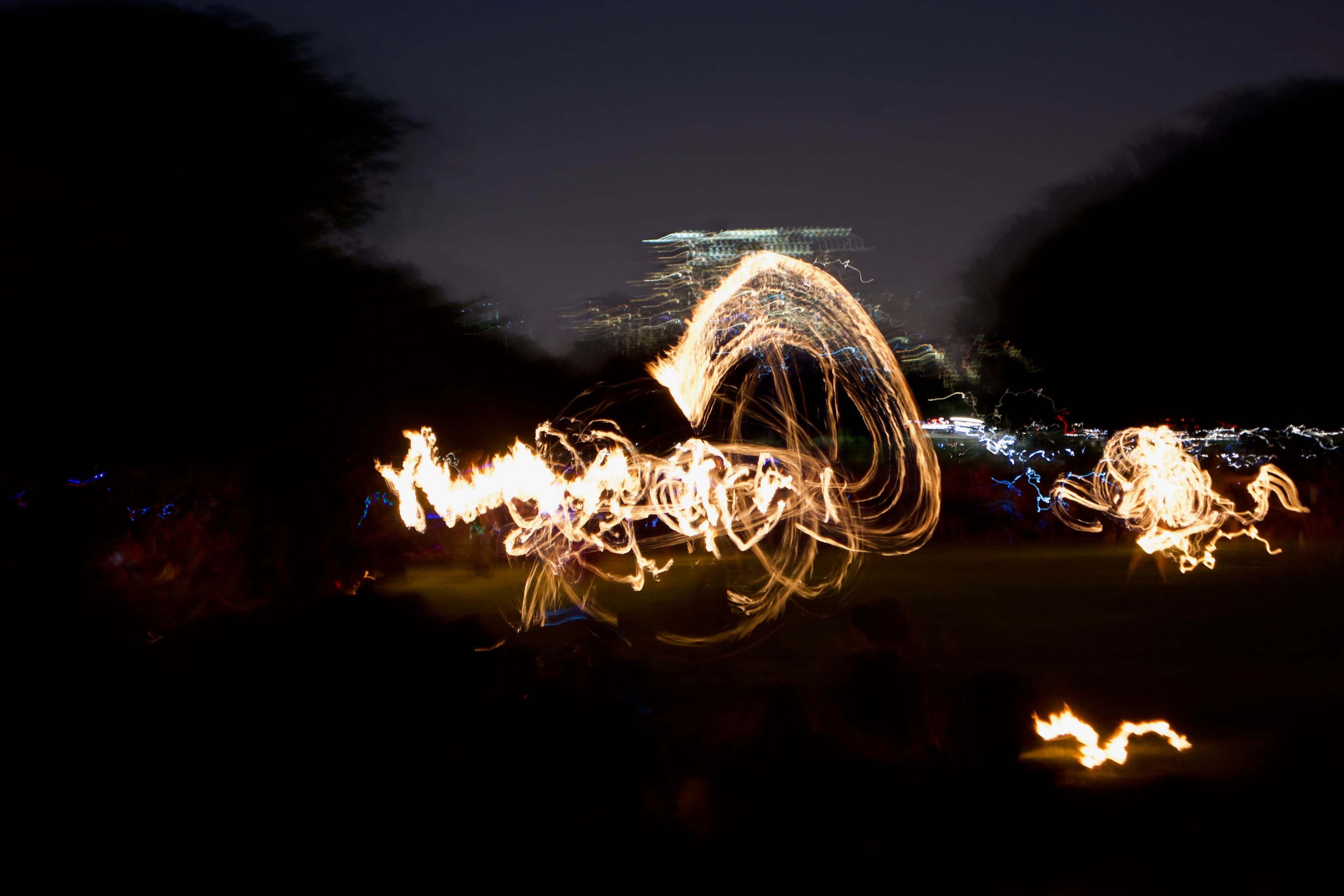 Nightfire Dance - Long-exposure shot of fire dancers at night, creat...