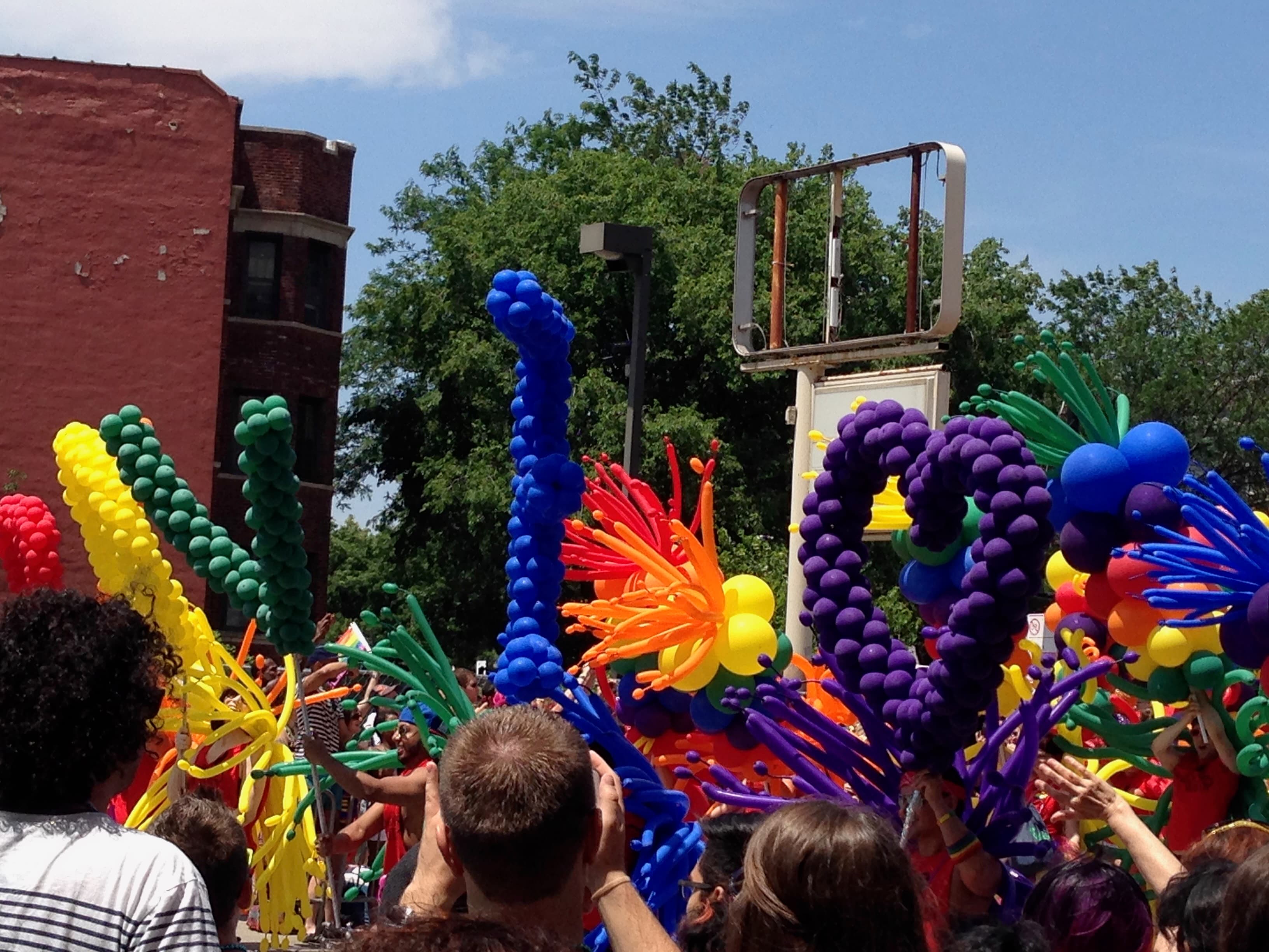 Rainbow Riot - Vibrant balloon sculptures and joyful crowd at a P...