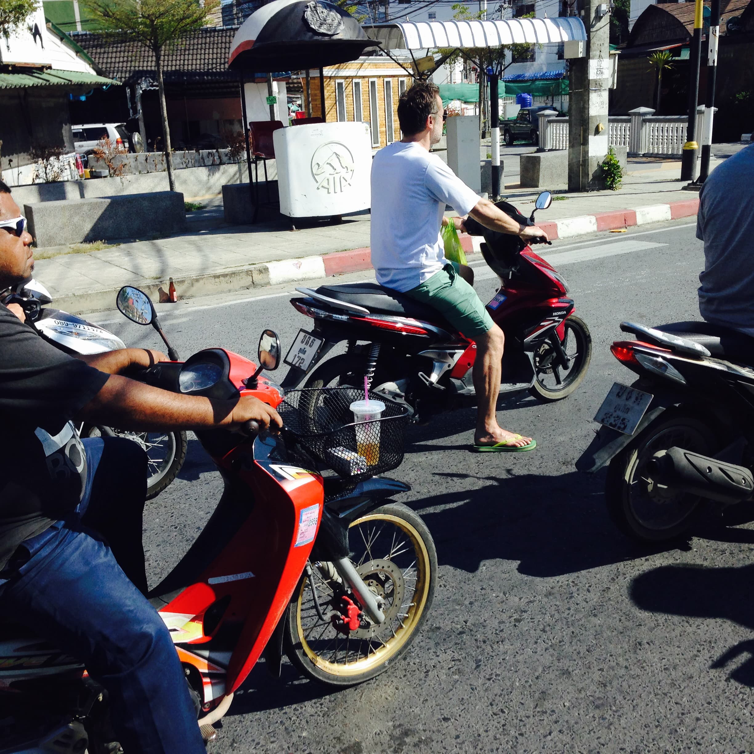 Urban Heat: Southeast Asia - Three motorcyclists navigate a sun-drenched street...