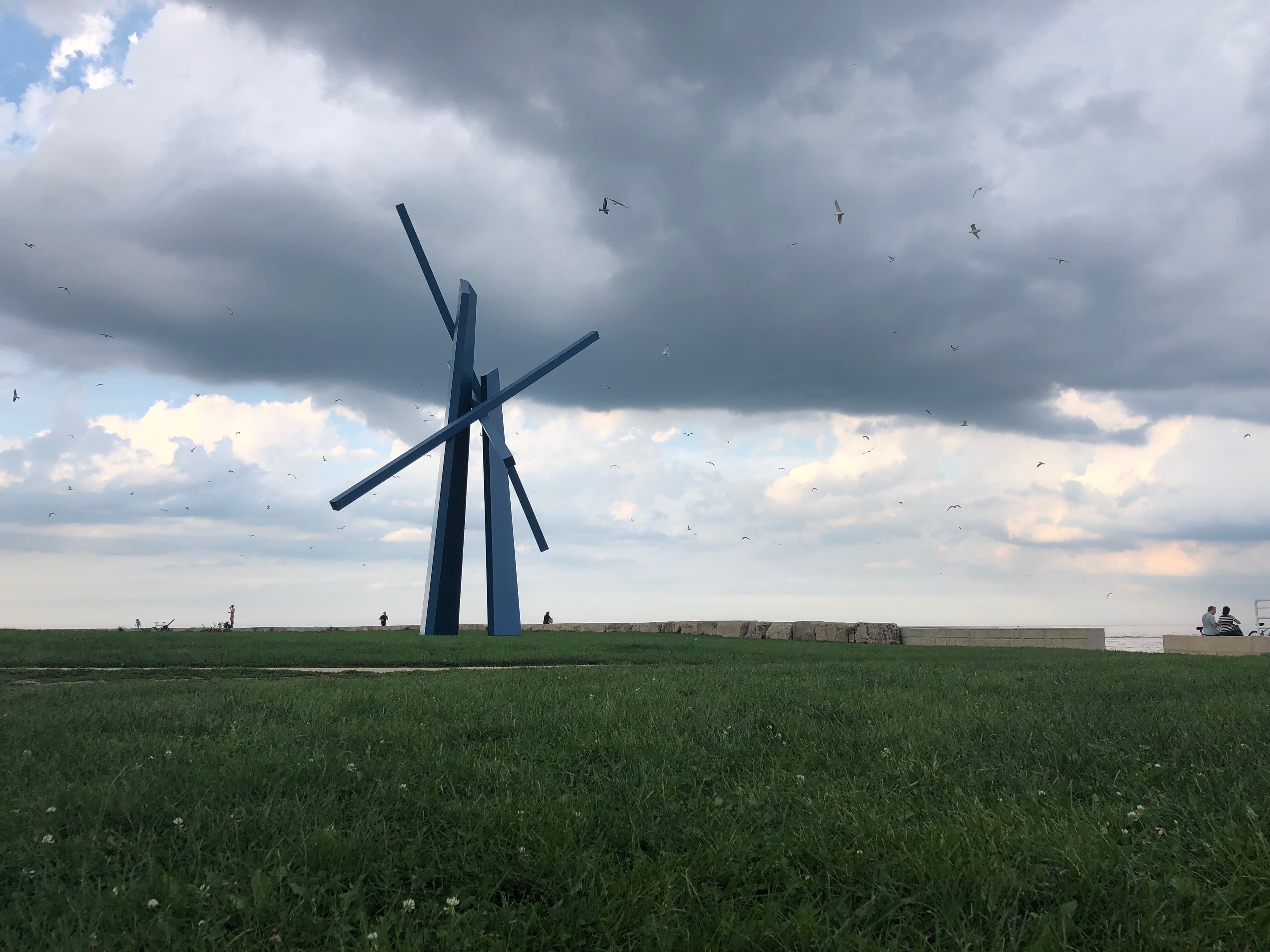 Steel Wings and Grey Skies - A blue steel sculpture stands in a green field, si...