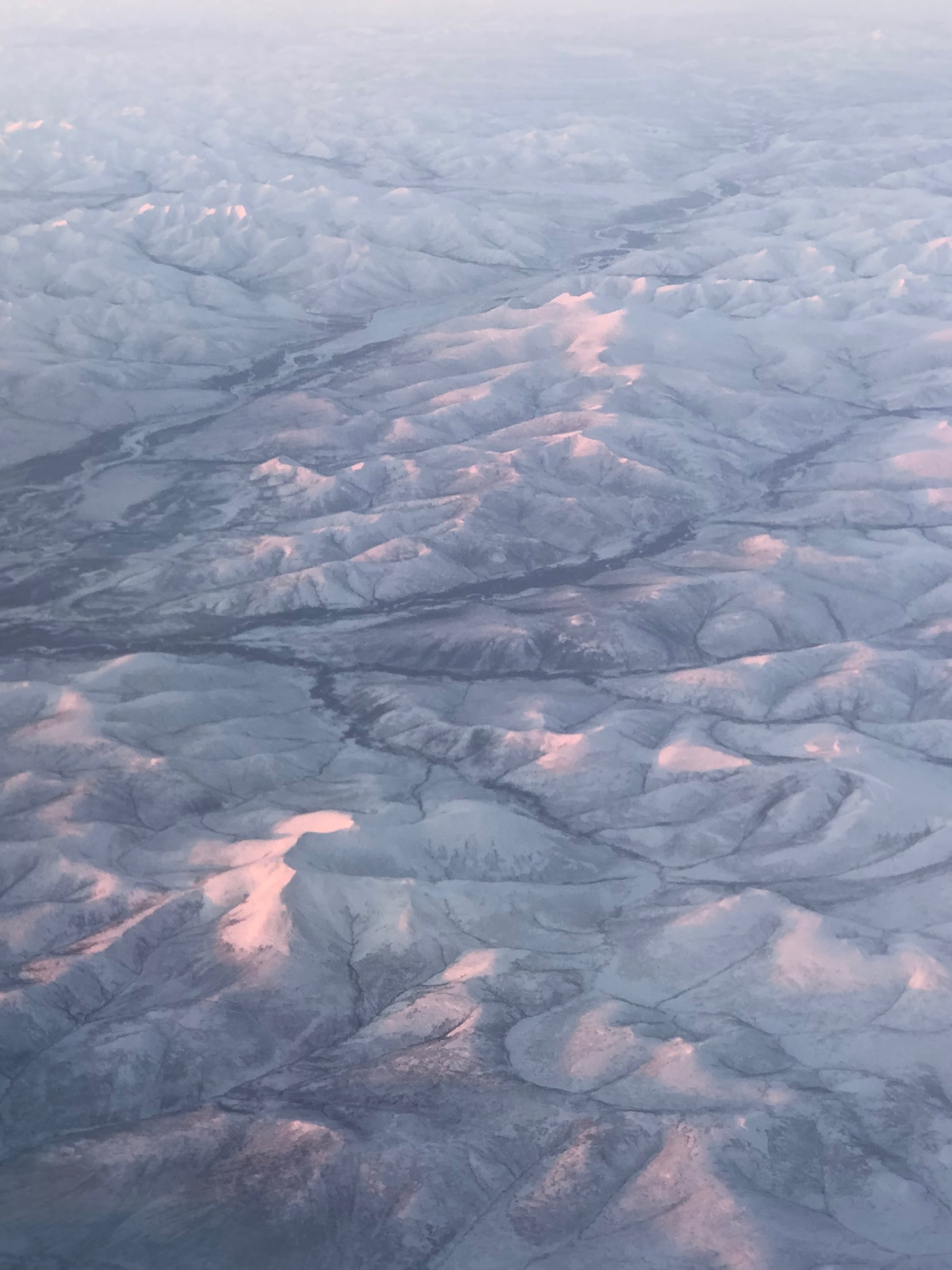 Aerial Winter's Embrace - A serene, bird's-eye view of snow-covered mountain...