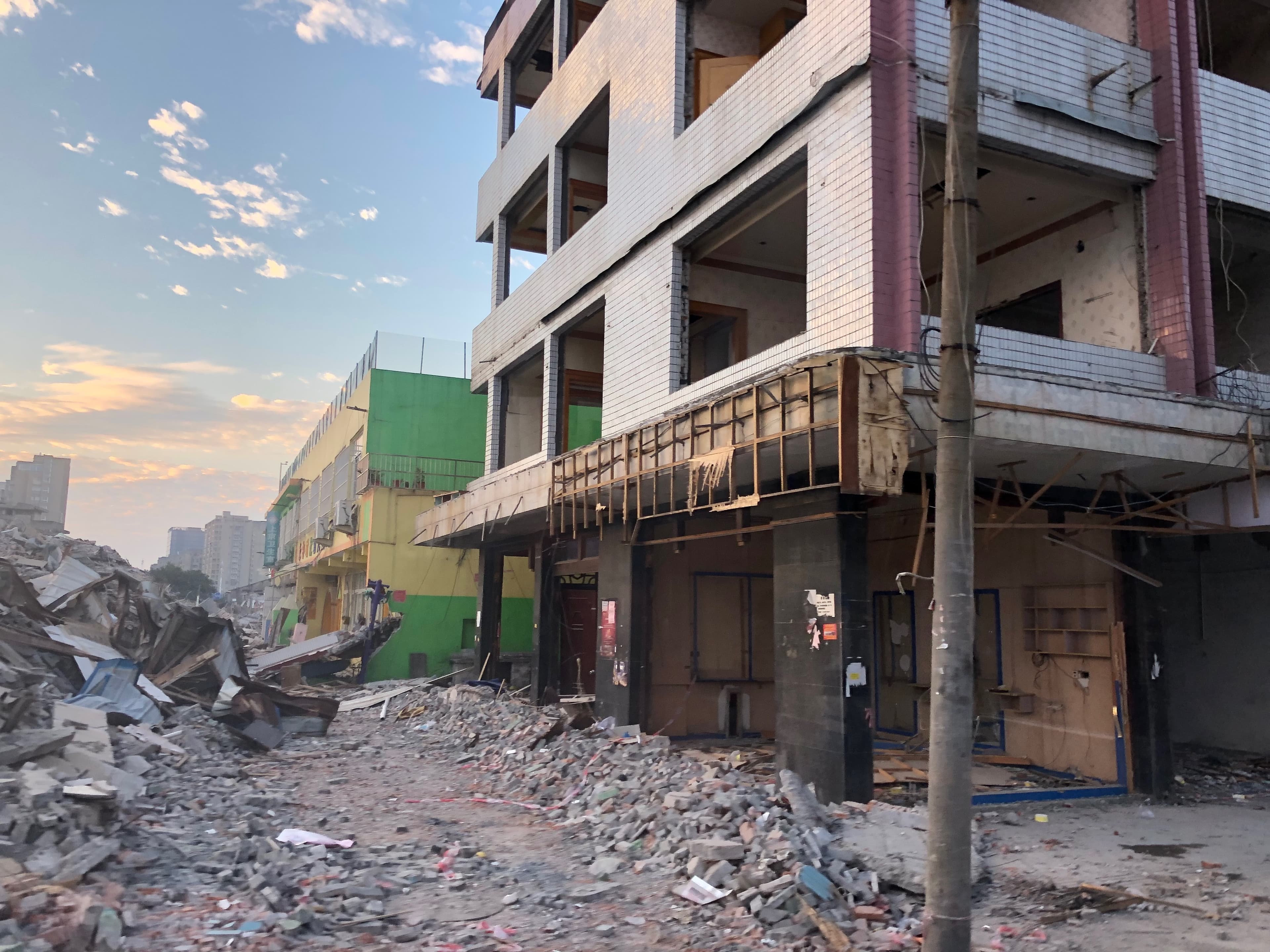 Urban Decay: Sunset Ruins - A partly demolished building at sunset, rubble and...